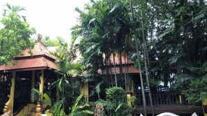 A traditional building with a red roof, surrounded by lush greenery and a staircase with golden balustrades. - Pichawaree Resort (Si Thep)