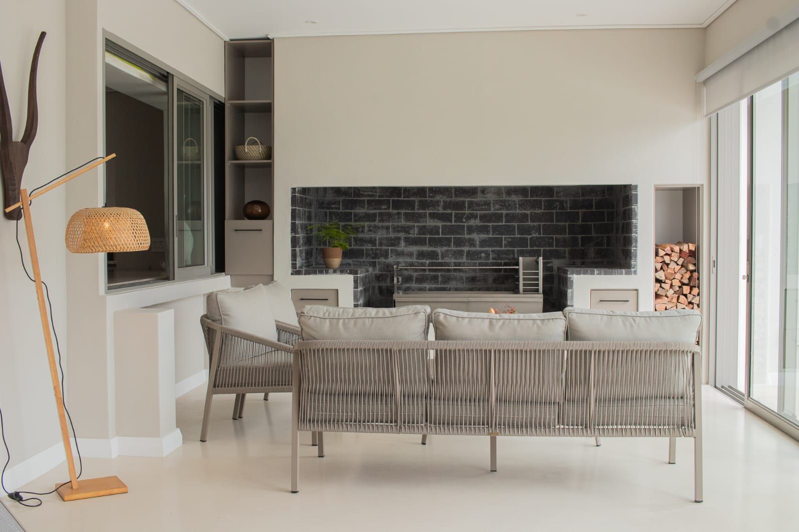 Una sala de estar moderna con sofá, chimenea y un amplio ventanal.