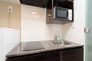 A kitchen with a microwave, sink, and a tablet on the counter. - LaVie Hatsudai (Tokyo)