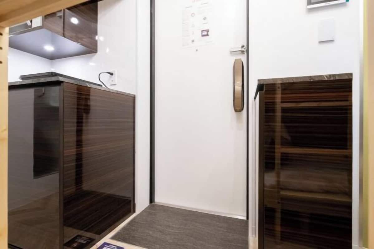 A room with a wooden cabinet, a white door, and a wooden-framed window.