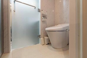Ein Badezimmer mit Toilette, Glastür und Marmorwand.