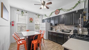 Une cuisine de taille réduite comprenant une table à manger, des chaises et une cuisinière.