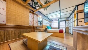 A traditional Japanese-style room with tatami flooring, a low wooden table, and a futon bed. - SHIN Hotel Victory Monument (Bangkok)