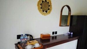A hotel room with a wooden counter, a mirror, and a wall-mounted decorative item. - d’Kelingking Secret Villas (Bali)