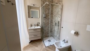 A modern bathroom with a shower, bidet, and a mirror. - Comfortable and stylish room near central station and airport (Napoli)