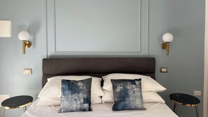 A bedroom with a bed, two wall-mounted lamps, a night switch, and a night switch on the wall. - Comfortable and stylish room near central station and airport (Napoli)