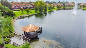 A lakeside view with a gazebo, a small deck, and a fountain in the background. - 3bd/2.5ba Private Jacuzzi King Bed (Kissimmee)