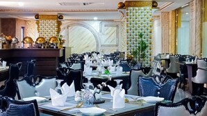 A formal dining room with multiple tables set for service, featuring black upholstered chairs and white table settings. - AAHotel Abuja (Abuja)