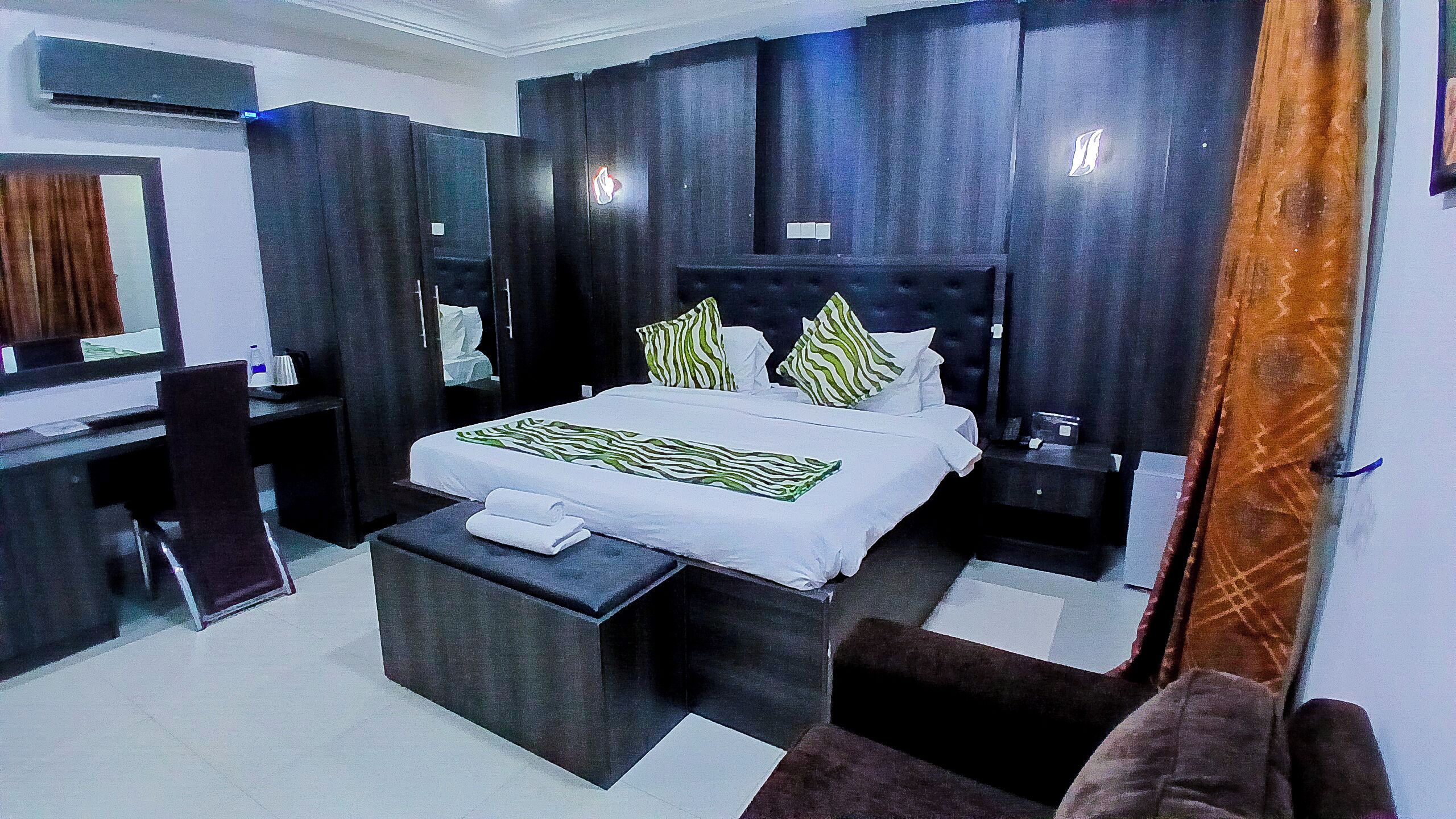 Una habitación de hotel moderna con una cama grande, un escritorio y una silla.