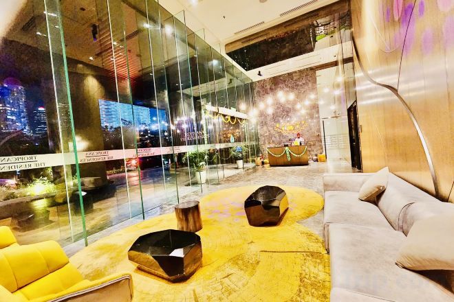A modern lobby with a glass wall, a sofa, and a round table.