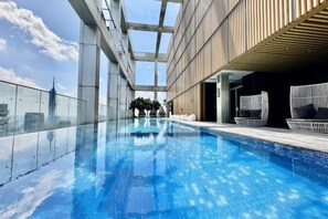 An indoor swimming pool with a clear view of the sky and a modern architectural design. - Queen Suites Tropicana The Residence by KLCC (Kuala Lumpur)