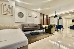 A modern living room with a sofa, armchair, and coffee table. - Queen Suites Tropicana The Residence by KLCC (Kuala Lumpur)