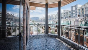 Una habitación con ventanas amplias, techo de madera y vistas a otros edificios.