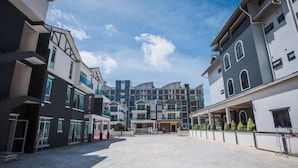 Un moderno complejo de edificios con varios pisos, ventanas amplias y un patio central.