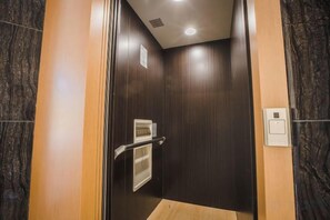 An elevator interior with a wooden floor, a handrail, and a control panel. - Barrington Villa @ Golden Hill (Brinchang)