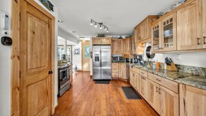 A kitchen with wooden cabinets, stainless steel appliances, and a granite countertop. - Pine Lantern Retreat (South Lake Tahoe)