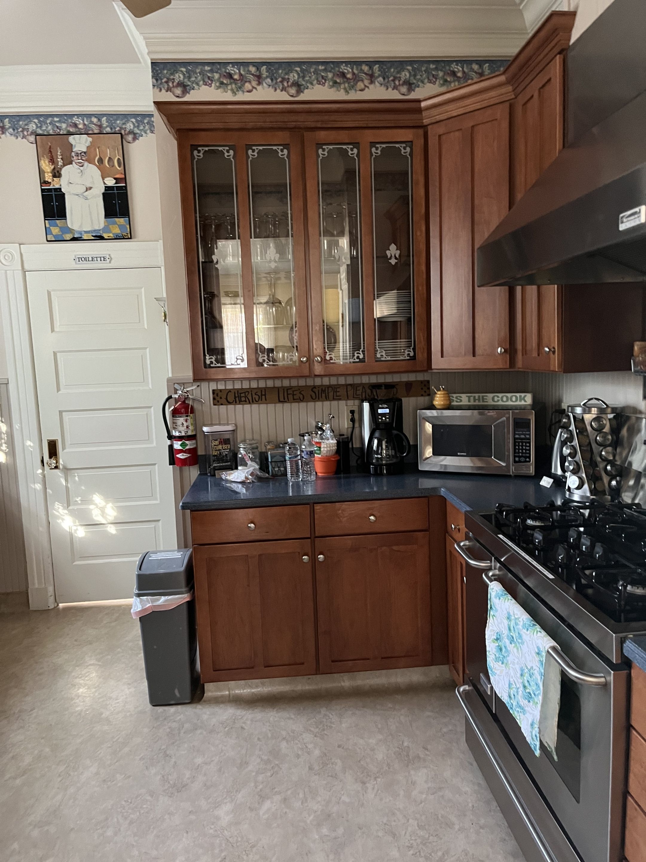 A kitchen with wooden cabinets, a stainless steel stove, and a microwave.