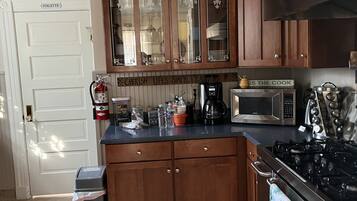 A kitchen with wooden cabinets, a stainless steel stove, and a microwave.