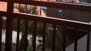 A waterfront view with a wooden deck, boats, and a sunset. - Sandpiper Cove 8249 Studio In Destin, FL  2-minute walk to the beach! (Destin)