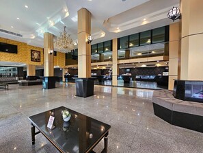 A spacious lobby with a reception desk, seating areas, and a chandelier. - Boutique Bravo Hotel (Pattaya)