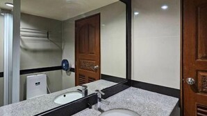 Un bagno con lavandino, specchio e porta in legno.
