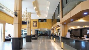 A spacious lobby with a reception desk, seating areas, and a chandelier. - Boutique Bravo Hotel (Pattaya)