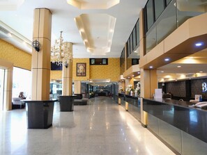 A spacious lobby with a reception desk, seating areas, and a chandelier. - Boutique Bravo Hotel (Pattaya)