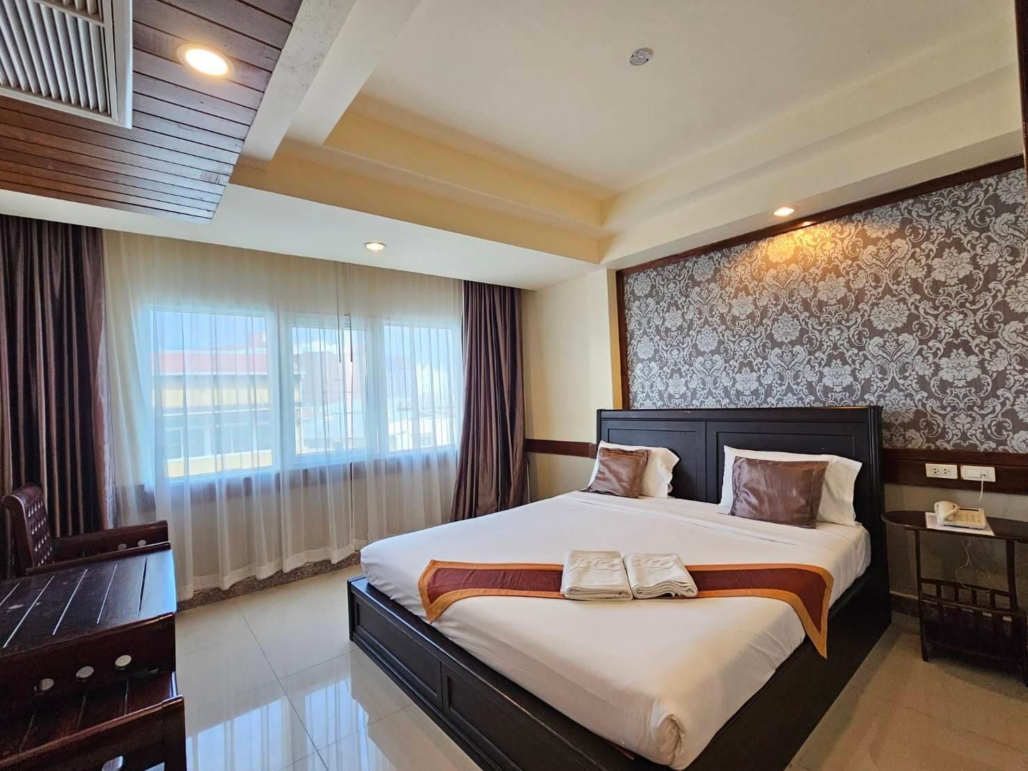 Een hotelkamer met een groot bed, een bureau en een stoel.
