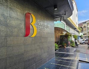 A storefront with a large, bold logo and the name 'BOUTIQUE BRAVO' on the wall. - Boutique Bravo Hotel (Pattaya)