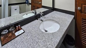 A bathroom with a large mirror, a sink, and a door. - Boutique Bravo Hotel (Pattaya)
