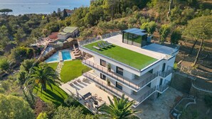 Ein modernes, zweistöckiges Haus mit Dachgarten, Schwimmbad und Meerblick.