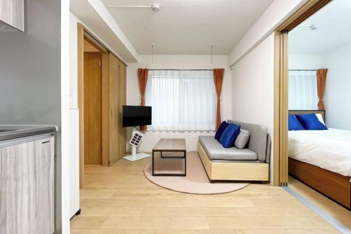 Una moderna camera d'albergo con un divano, un letto, una TV e un tavolino.