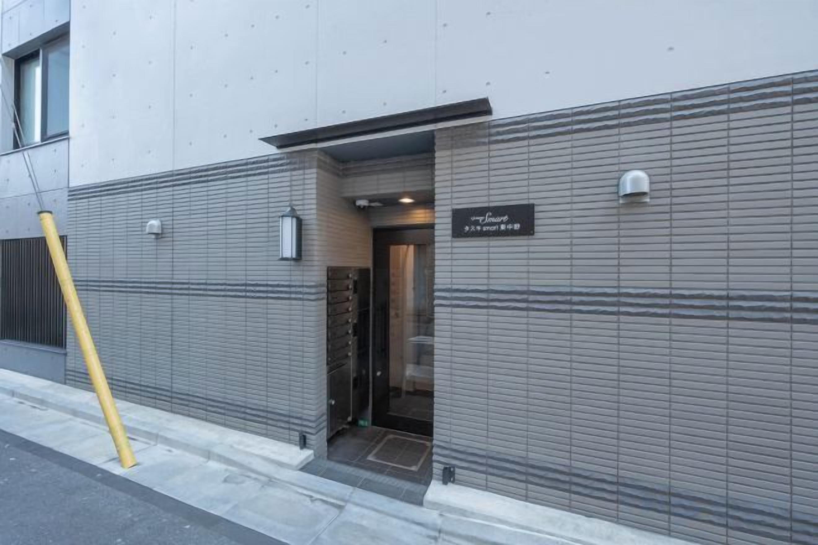 A building entrance with a metal door and a sign above it.