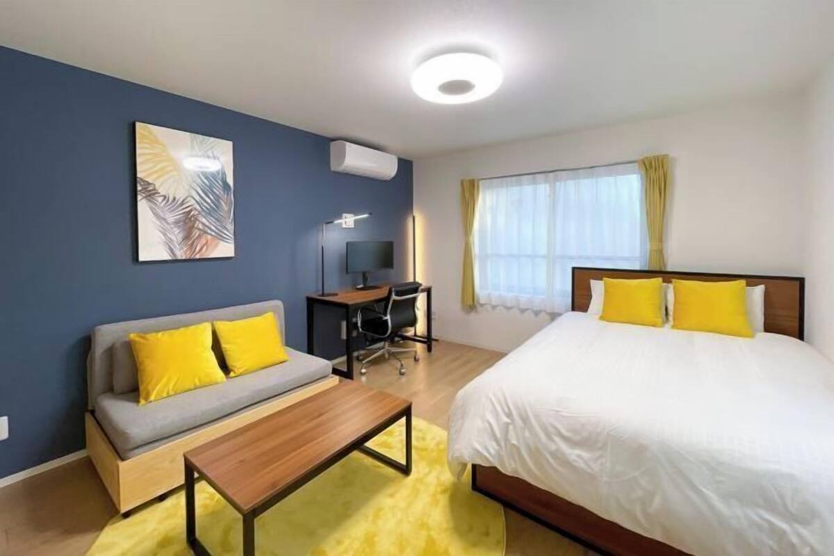 Una camera d'albergo con un letto, un divano, una scrivania e una sedia.