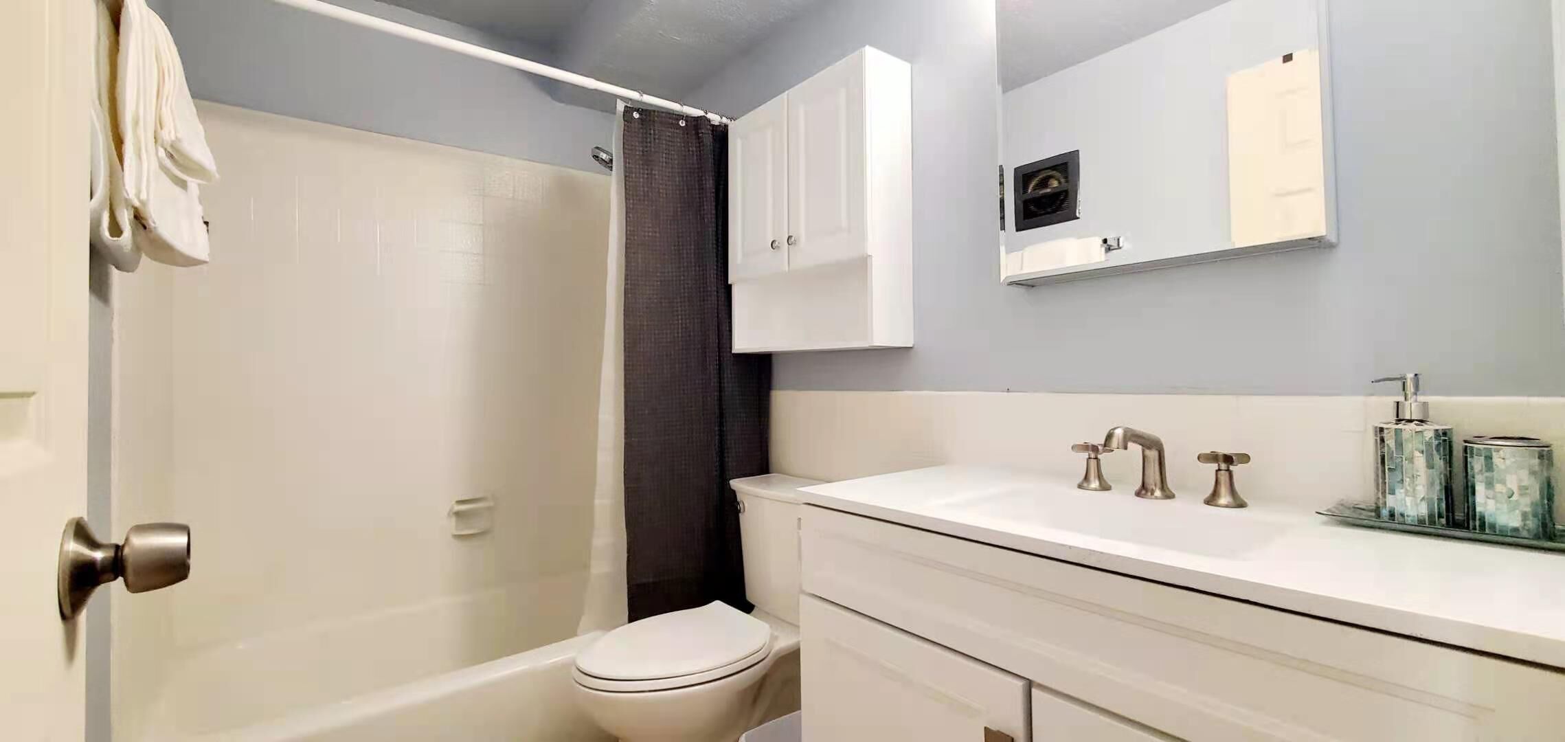 A bathroom with a bathtub, toilet, and a shower curtain.