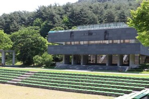 Un edificio con techo plano y un amplio espacio abierto al frente.