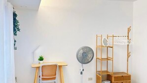 A master bedroom with a work desk, open wardrobe, and available hangers, hair dryer, and clothes iron.