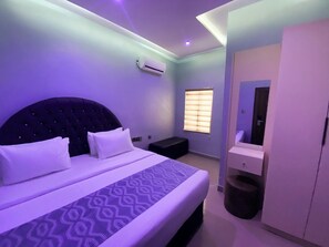 A modern bedroom with a large bed, a built-in wardrobe, and a window with blinds. - House 40 Residence (Abuja)
