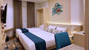 A hotel room with two beds, a desk, a chair, a TV, and a wall-mounted artwork. - Cordia Hotel Yogyakarta - Airport Hotel (Temon)