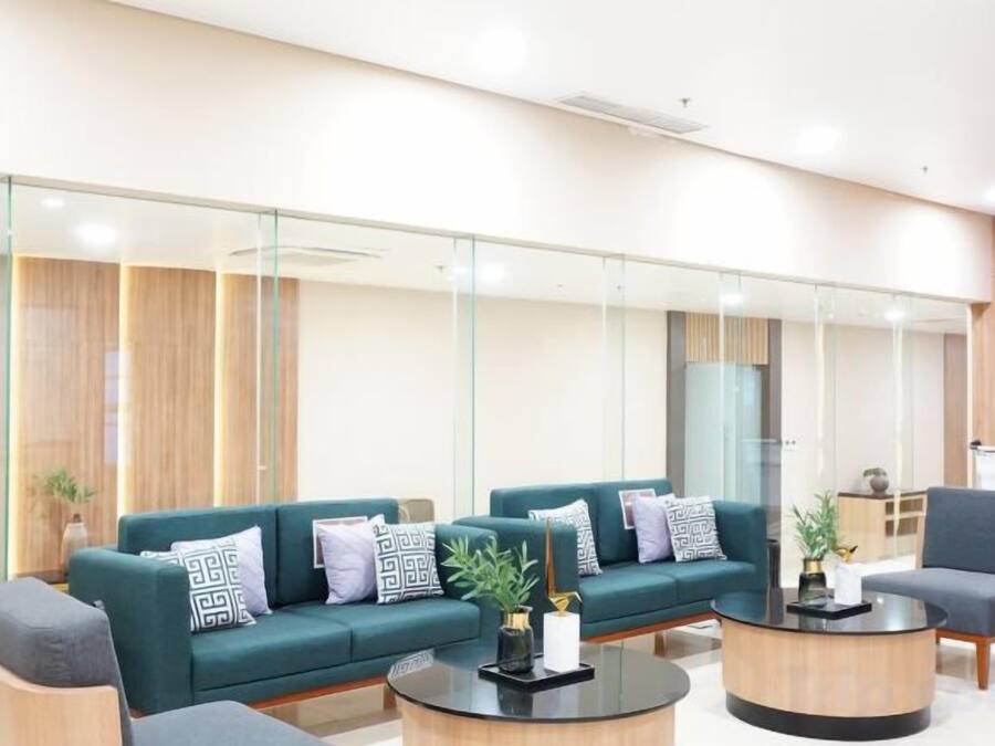 Un área de espera moderna con un conjunto de sofás, una mesa de centro y una silla.