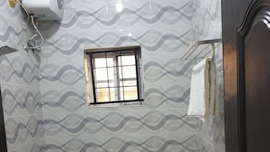 A small bathroom with a toilet, a window, and a shower. - Laylah Suites and Apartment (Gombe)