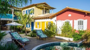 Un espace piscine avec des chaises longues et une petite piscine.