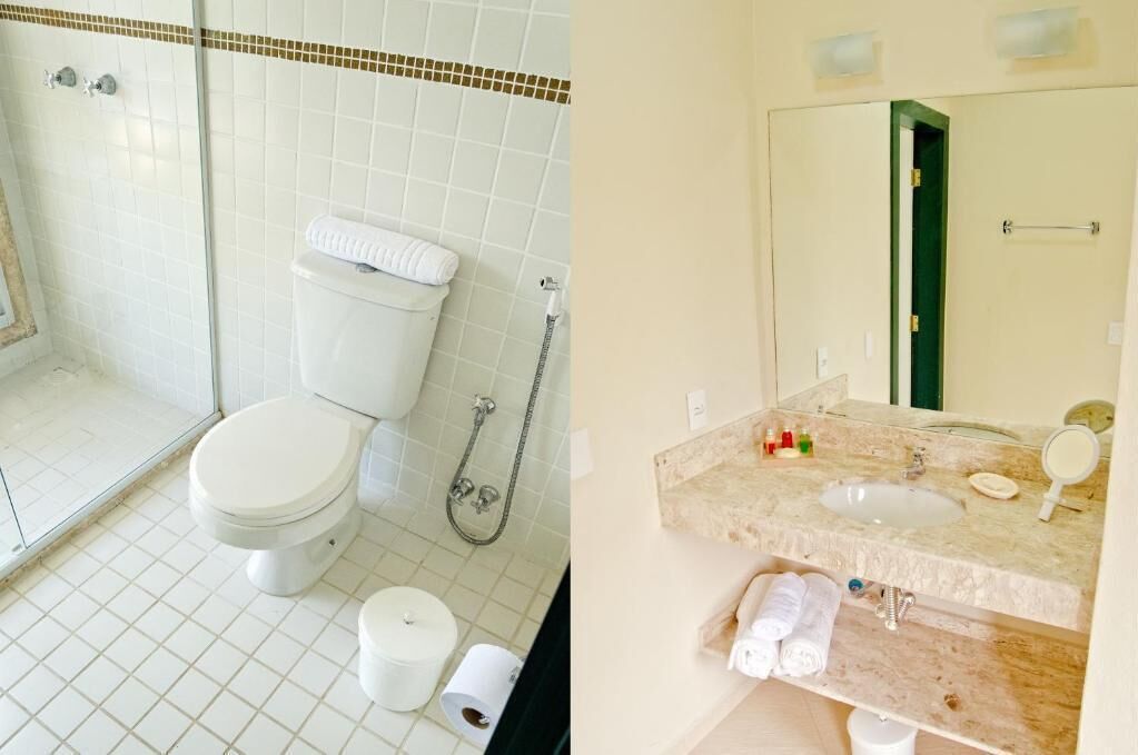 A bathroom with a toilet, shower, and sink.