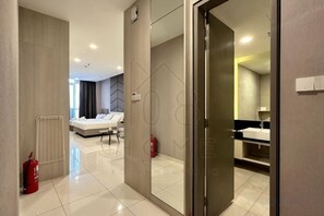 Une chambre d’hôtel comprenant un lit, une salle de bain et une porte vitrée donnant sur une autre pièce.