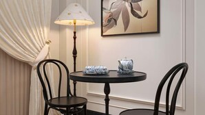 Ein Essbereich mit einem runden Tisch, zwei Stühlen, einer Lampe und einer Ziervase.