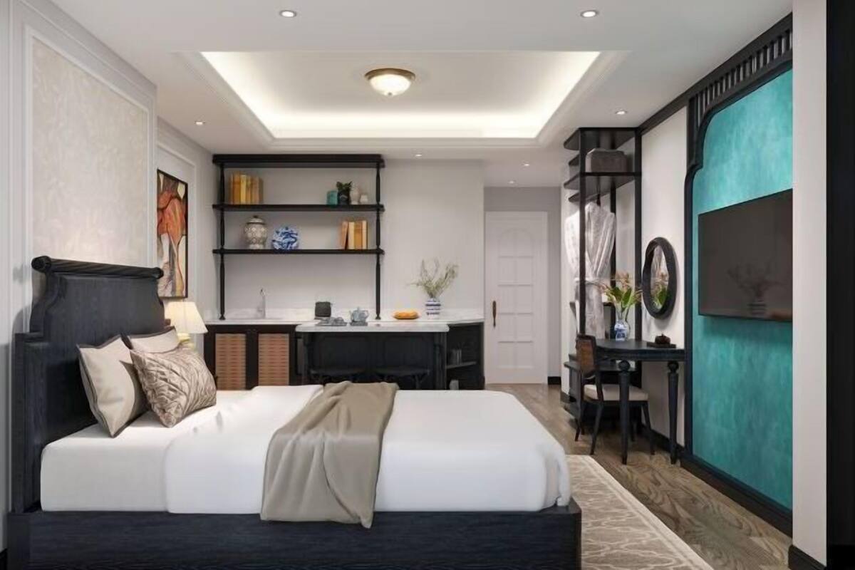A modern bedroom with a large bed, a desk, and a shelving unit.