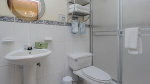 A bathroom with a sink, toilet, and a shower area. - Kontiki Miraflores  (Lima)