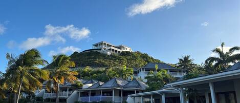 A resort with multiple bungalow-style buildings on a hillside, featuring balconies and a view of the surrounding landscape.