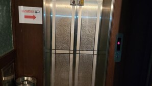 An elevator with a sign indicating the direction to the lobby. - Sisilli Motel (Uijeongbu)