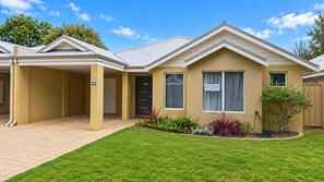 A two-story building with a covered entrance and a number 22 sign. - Cape View TwentyTwo – a modern 2-bedroom, 2-bathroom villa (Broadwater)